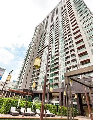 Modern high-rise building with luxurious amenities and outdoor lounging area.