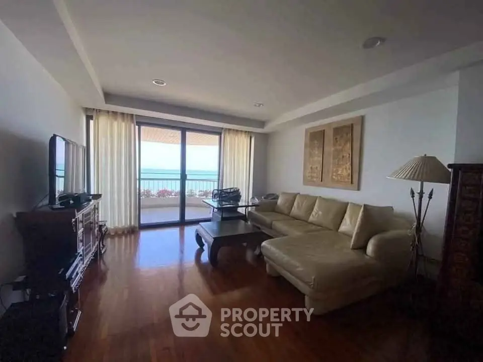 Spacious living room with ocean view and elegant furnishings in luxury apartment.
