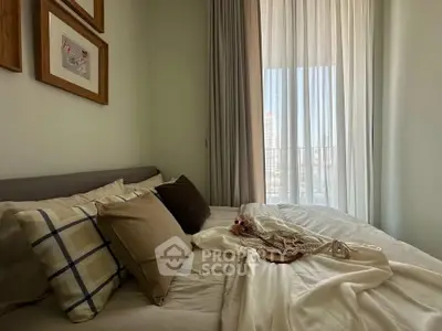 Cozy bedroom with elegant decor and large window offering natural light.