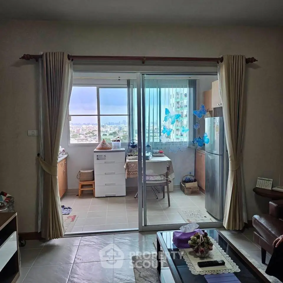 Cozy living room with sliding glass doors leading to a bright balcony with city views.