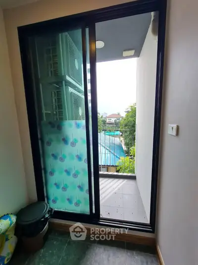 Charming balcony with sliding glass door and scenic view, perfect for relaxation and enjoying the outdoors.