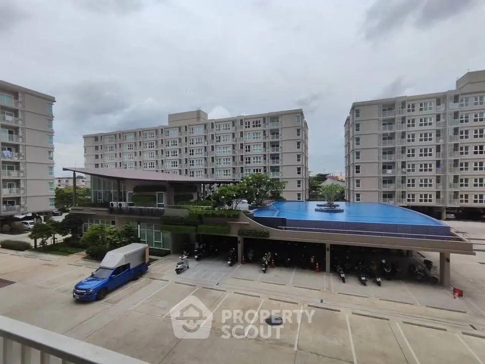 Modern apartment complex with pool and parking area, offering urban living with convenient amenities.