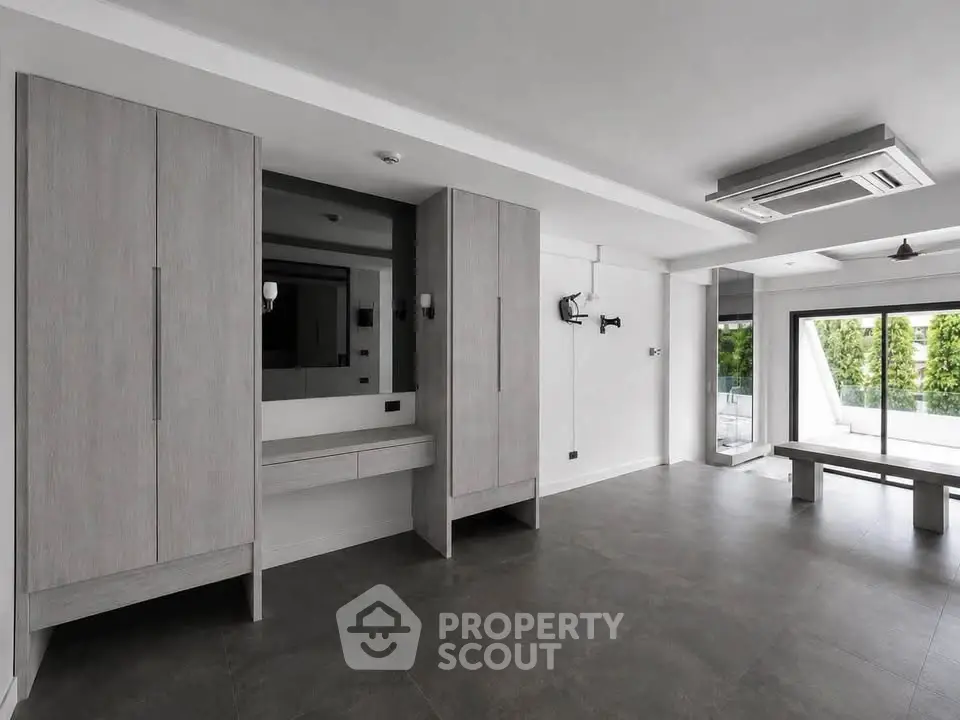 Spacious modern living room with sleek design and large windows offering natural light.