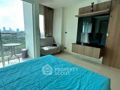 Modern bedroom with balcony and city view, featuring sleek furniture and vibrant decor.