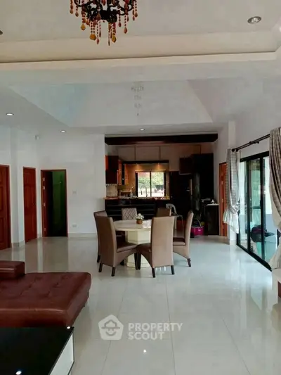 Spacious open-plan living and dining area with elegant decor and large windows for natural light.
