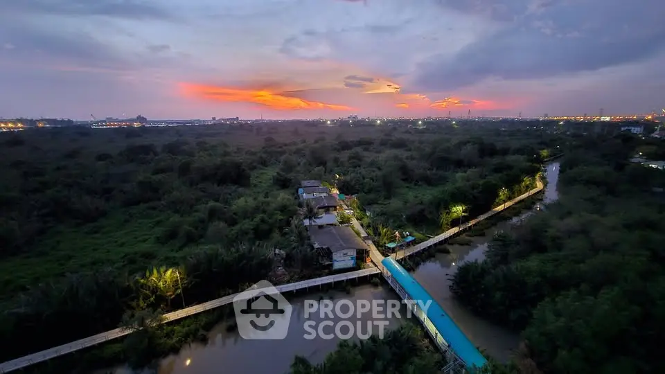 Stunning aerial view of lush greenery and serene waterway at sunset, perfect for tranquil living.