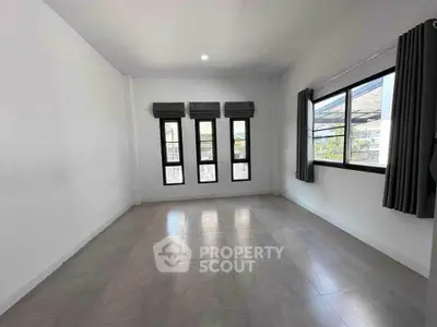 Spacious empty room with large windows and modern tile flooring, perfect for customization.