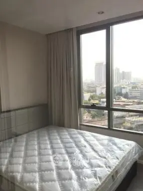 Bright bedroom with large window offering cityscape view
