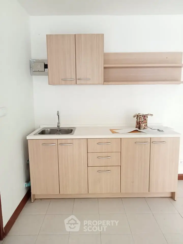 Modern kitchen with light wood cabinets and sleek countertop in a minimalist design.