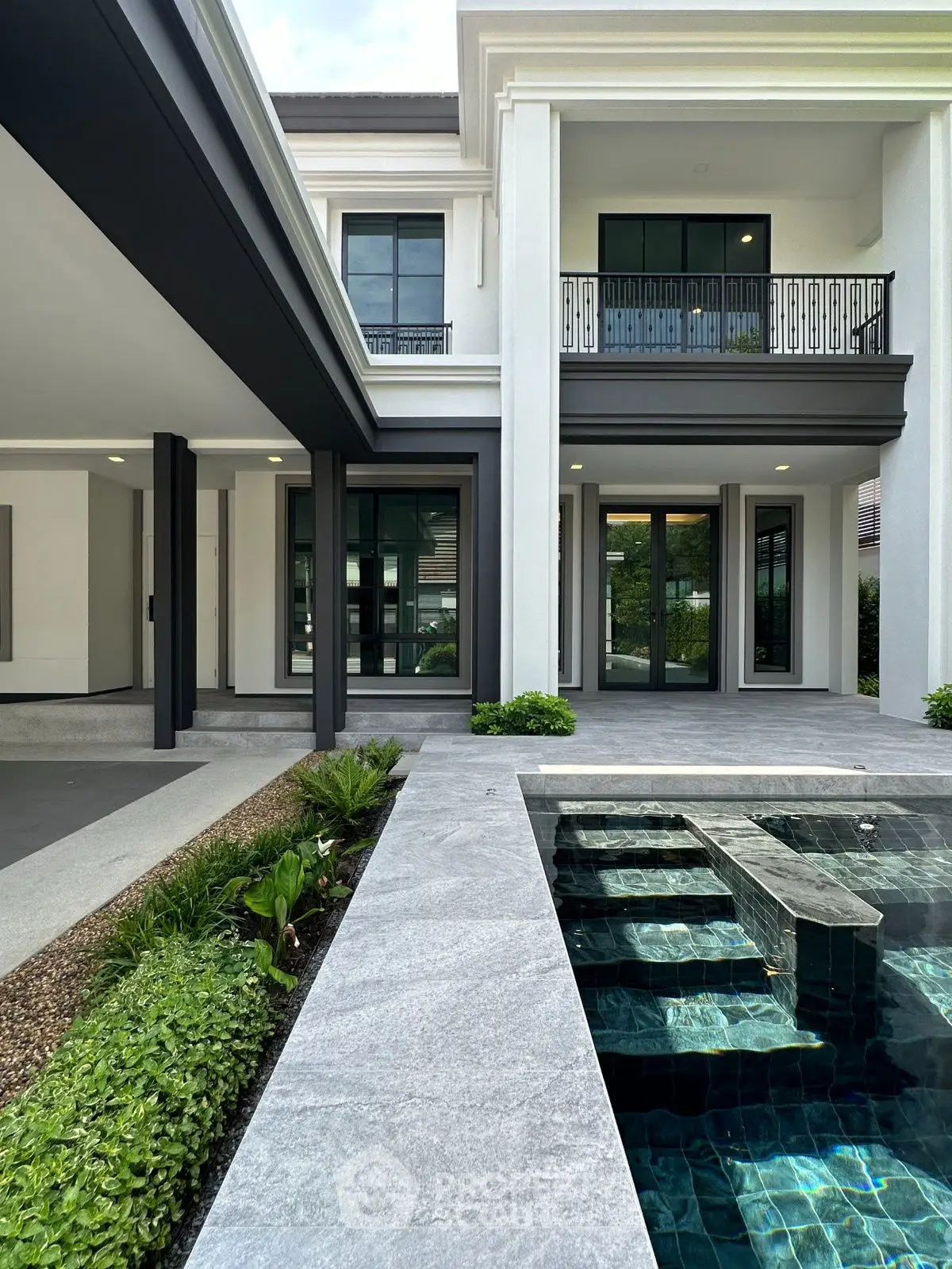 Luxurious modern home exterior with elegant pool and spacious patio area, perfect for entertaining.