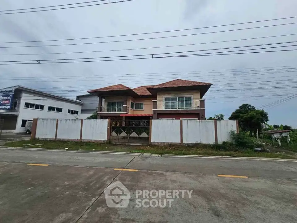 Spacious two-story house with a tiled roof and gated entrance, perfect for family living.