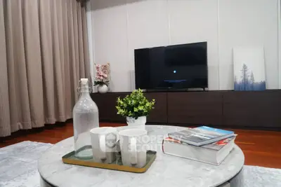 Stylish living room with modern decor, TV, and cozy seating area.