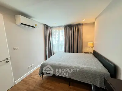 Spacious bedroom with modern decor and natural light in a stylish apartment.