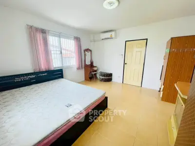 Spacious bedroom with natural light and modern furnishings for comfortable living.