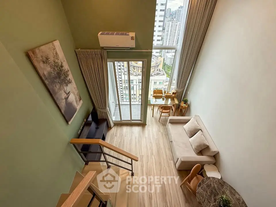 Modern loft apartment with high ceilings and city view, featuring stylish furniture and natural light.