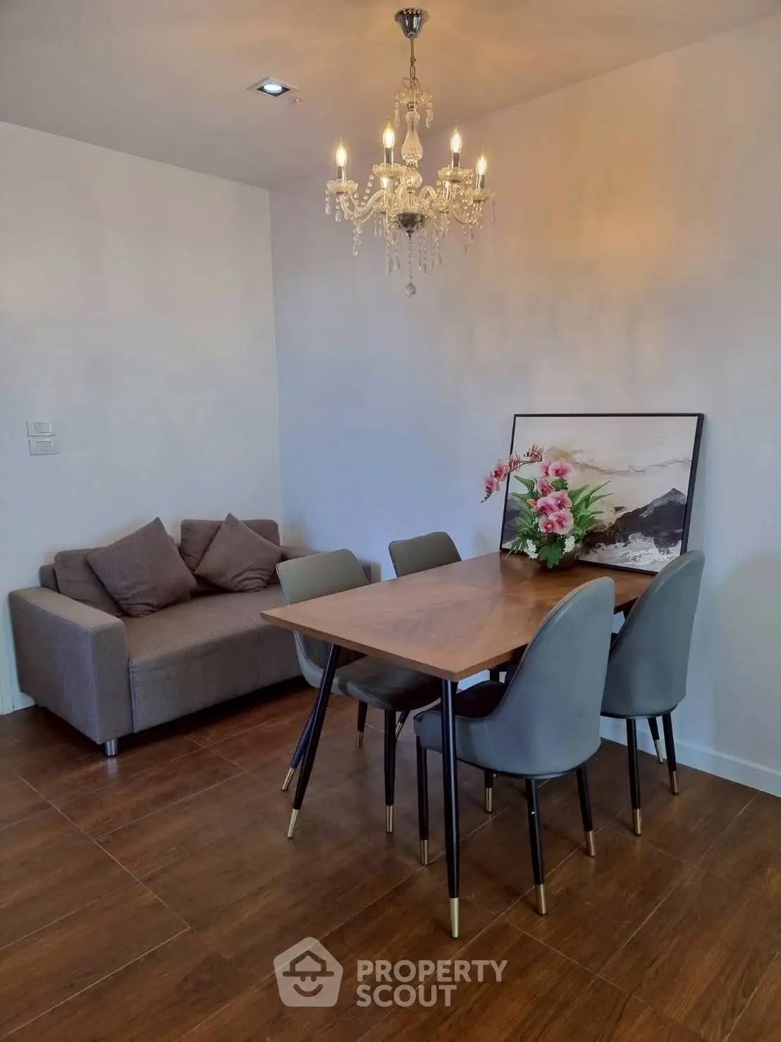 Elegant dining area with chandelier and modern furniture in a cozy apartment setting.