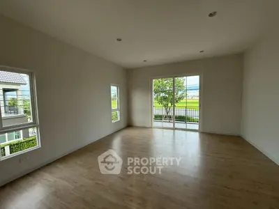Spacious empty living room with large windows and balcony view
