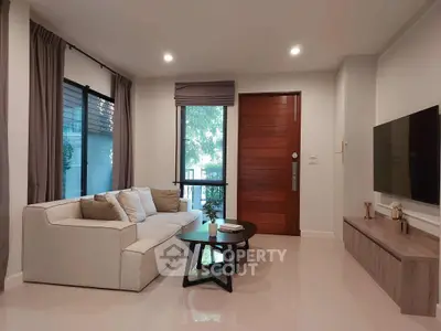 Modern living room with sleek design, cozy sofa, and wall-mounted TV, perfect for relaxation.
