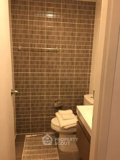 Modern bathroom with tiled walls and sleek fixtures in a contemporary home.