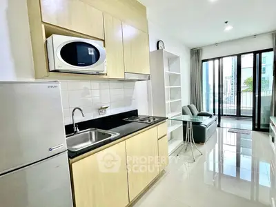 Modern open-layout kitchen and living room with balcony view in urban apartment