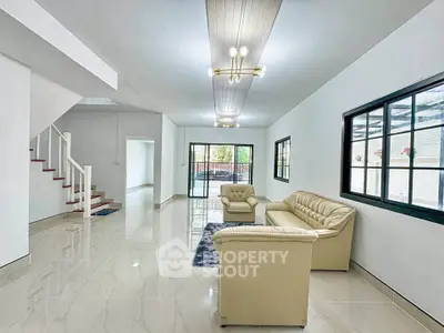 Spacious modern living room with elegant beige sofas and large windows.