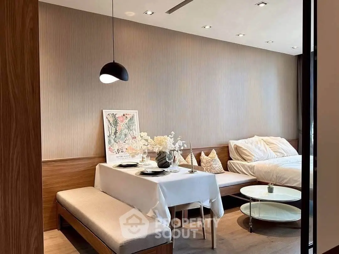 Stylish modern living room with dining area and cozy bed setup, perfect for urban living.