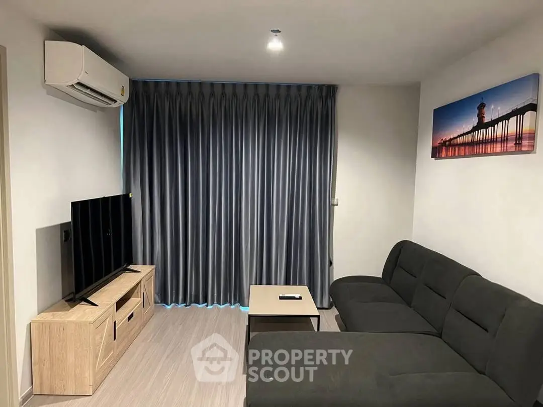 Modern living room with sleek furniture and wall art, featuring a cozy sectional sofa and flat-screen TV.