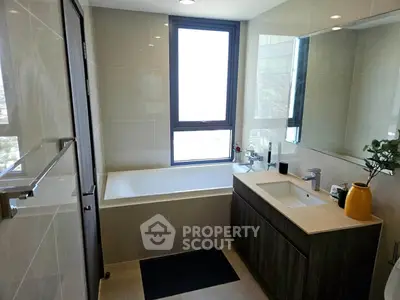 Modern bathroom with sleek design, featuring a bathtub and large mirror, perfect for relaxation and style.
