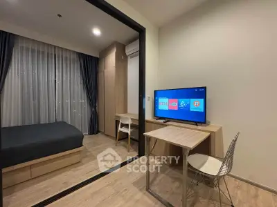 Modern studio apartment with sleek design, featuring a cozy bedroom and compact workspace with TV.
