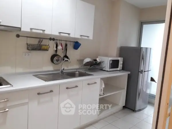 Modern kitchen with sleek white cabinets and stainless steel appliances
