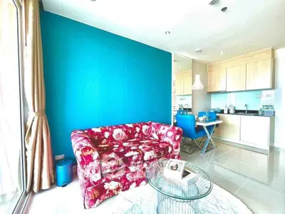 Stylish living room with vibrant floral sofa and modern kitchen in open layout apartment