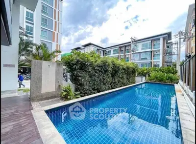 Modern condominium with a stunning outdoor pool and lush greenery.