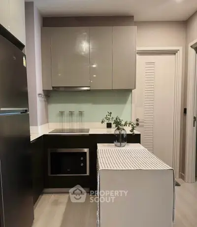Modern kitchen with sleek cabinetry and built-in appliances in a compact layout.