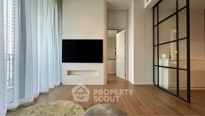 Modern living room with sleek design, wooden flooring, and large windows for natural light.