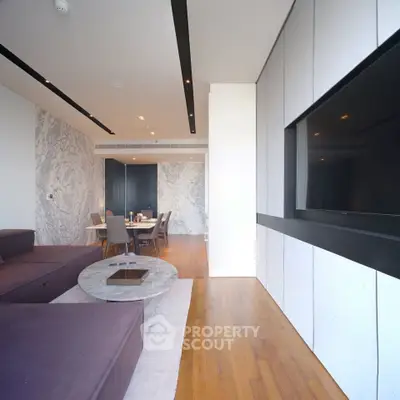 Luxurious modern living room with sleek design and elegant dining area, featuring hardwood floors and a large TV.