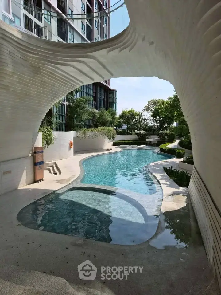 Luxurious modern apartment pool with unique architectural design and lush greenery.