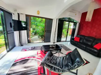 Stylish living room with modern decor and garden view, featuring sleek furniture and vibrant accents.