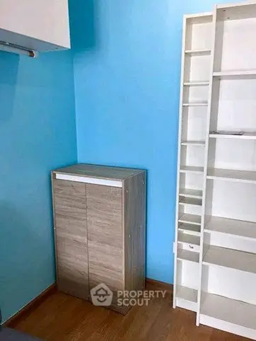 Compact storage room with modern shelving and cabinet in vibrant blue setting.