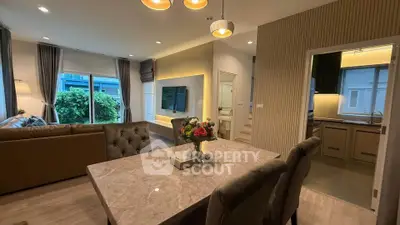 Elegant open-plan living and dining area with modern decor and large windows.