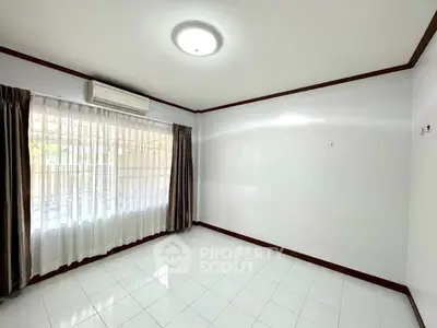 Spacious empty room with large window and air conditioning, perfect for customization.