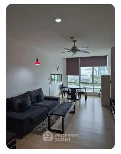 Modern living room with large window and city view, featuring sleek furniture and contemporary design.