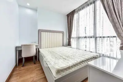 Bright and airy bedroom with large windows and elegant furnishings in modern apartment.