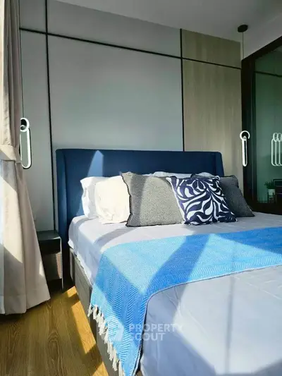 Modern bedroom with stylish decor and natural light, featuring a cozy bed and elegant design.