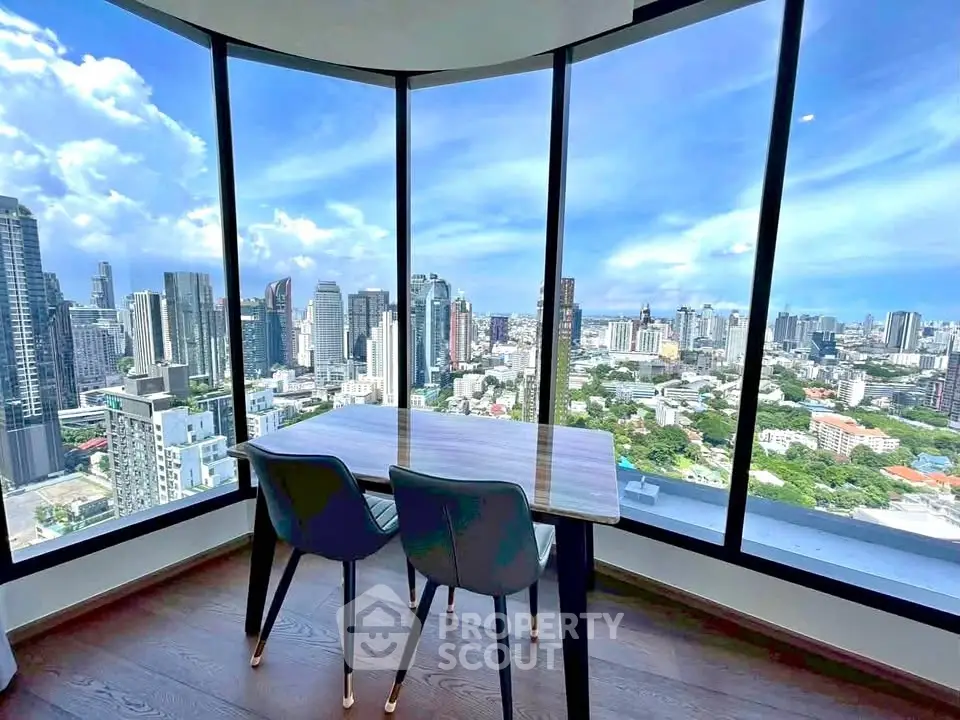 Stunning cityscape view from modern high-rise apartment with floor-to-ceiling windows and elegant dining area.