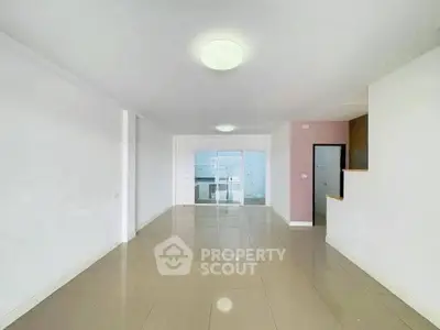 Spacious open-plan living room with modern tile flooring and bright lighting