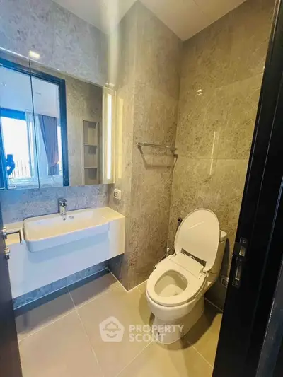 Modern bathroom with sleek design and large mirror in a contemporary apartment.