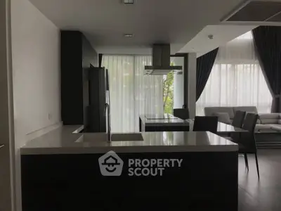 Modern kitchen with sleek design and open layout, featuring large windows and contemporary furniture.