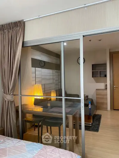 Modern apartment with glass partition, cozy living area, and elegant decor