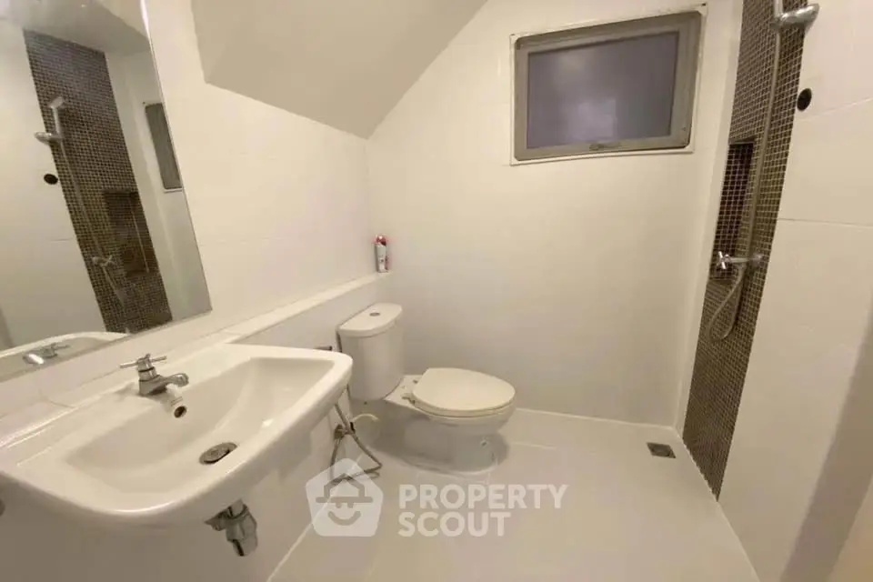 Modern bathroom with sleek white fixtures and a minimalist design.