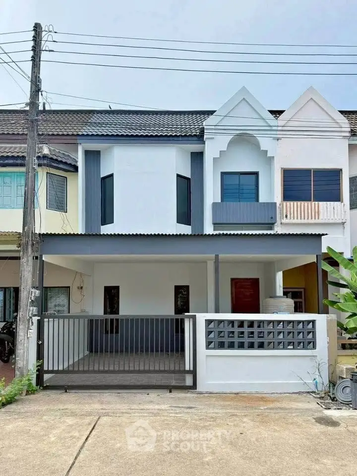 Charming townhouse with modern facade and gated driveway in a serene neighborhood.